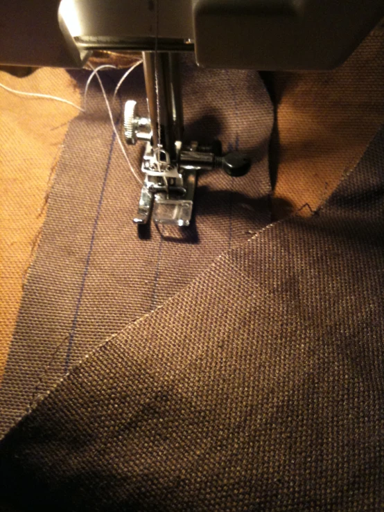 a sewing machine hooked to the front of a piece of cloth