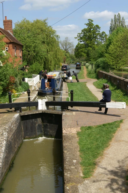 two people sitting on a bridge near water