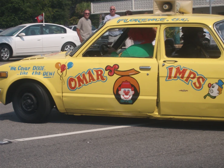 the small yellow car is decorated with colorful writing