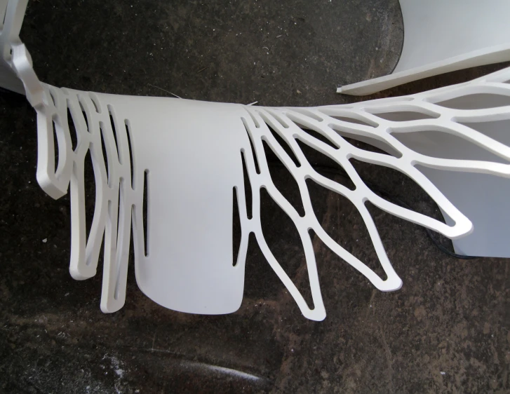 a white plastic sculpture with curved lines