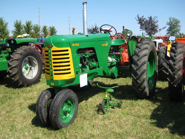 several farm tractors sitting in the grass