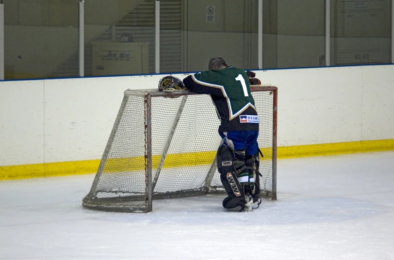 the goalie has his arms wrapped around the net