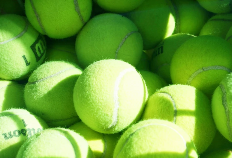 a large pile of green tennis balls