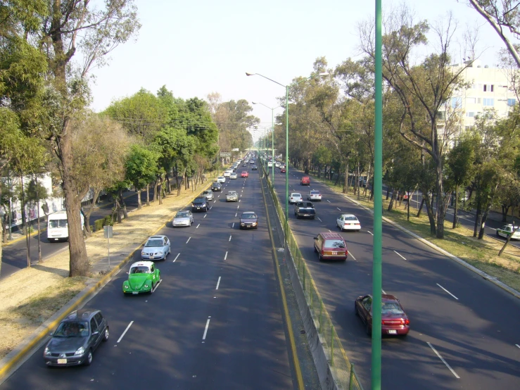 cars are travelling down an empty street during the day