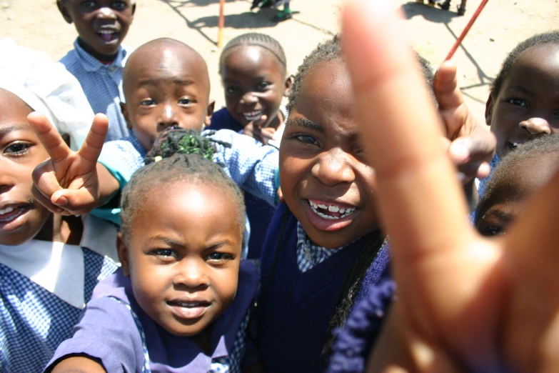 there are children with the peace sign raised in the air