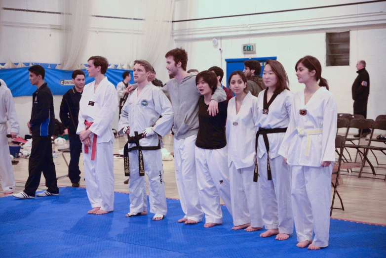 several people standing on a blue carpet wearing white