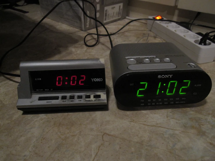 an alarm clock and alarm radio beside each other