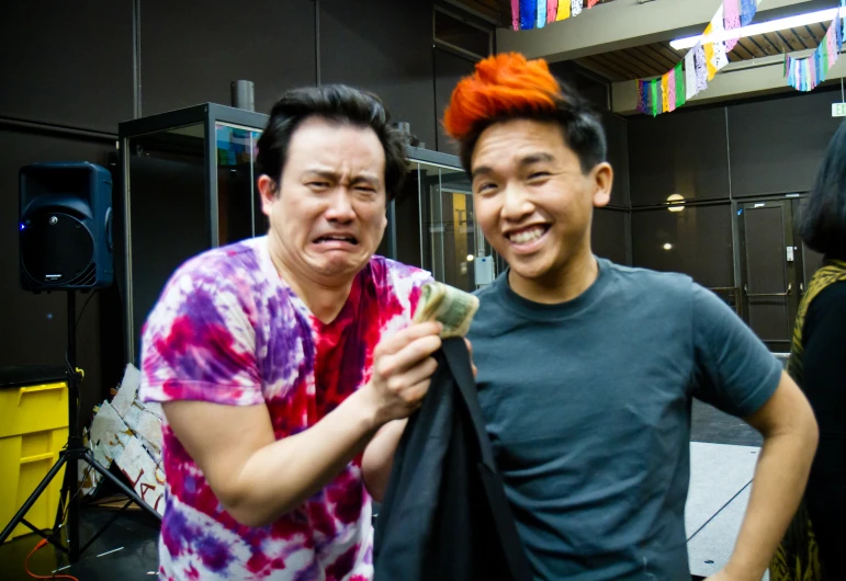 two men with orange mohawks posing for a po