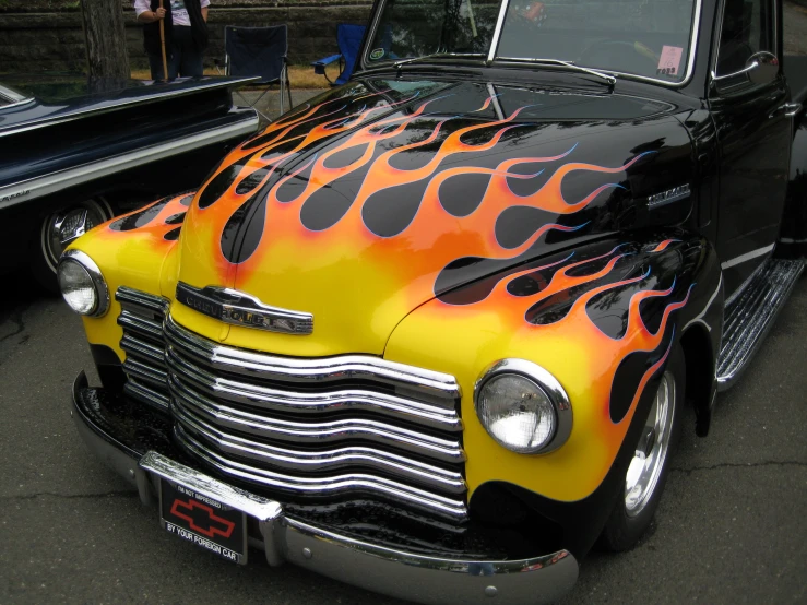 an old car with flames painted on it's hood