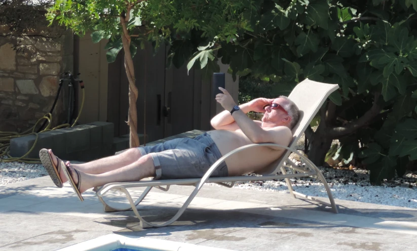 a man relaxing in his lawn chair with his cell phone