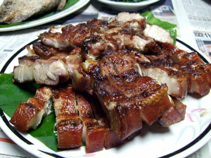 a plate with cooked meat on it sitting on a table