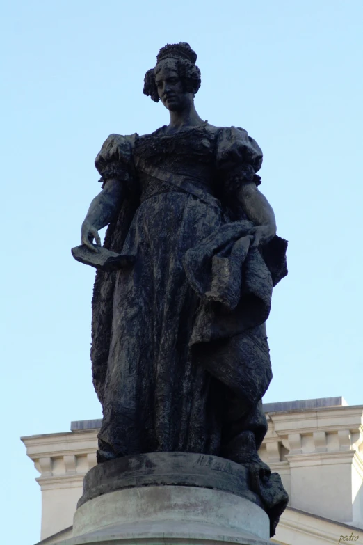 statue of woman holding bird next to church dome