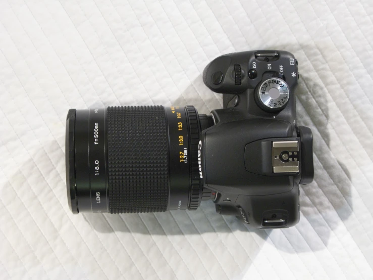 a camera is sitting on a bed with its lens pointed up