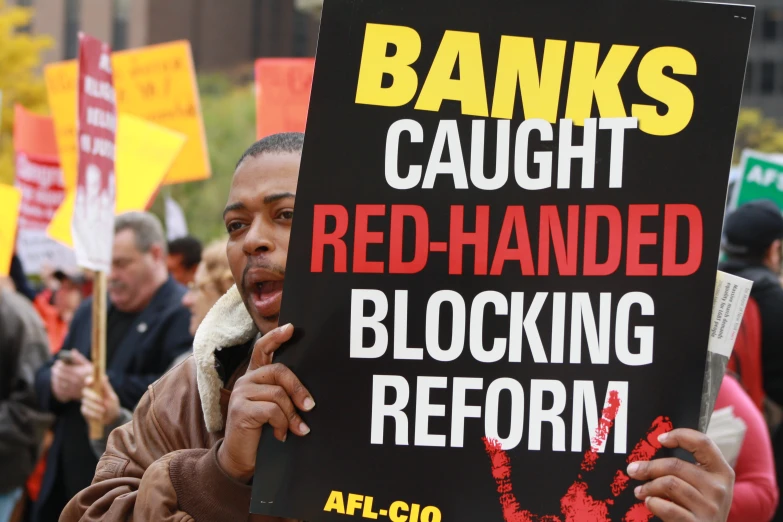 protestors holding signs in support of red - handed blocking california