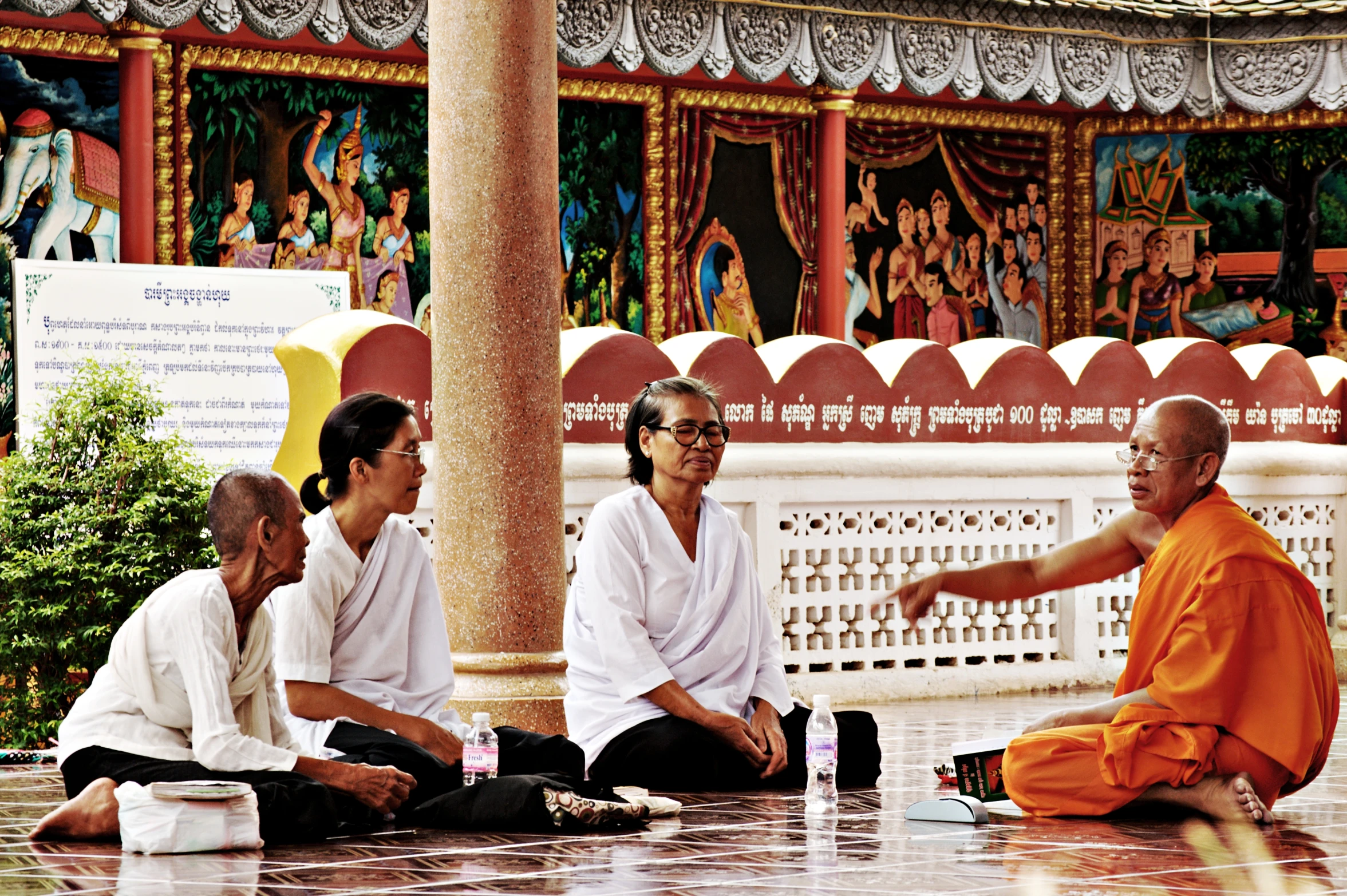 people sitting around on the ground near a statue