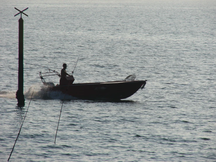 man in a boat on calm water at sea