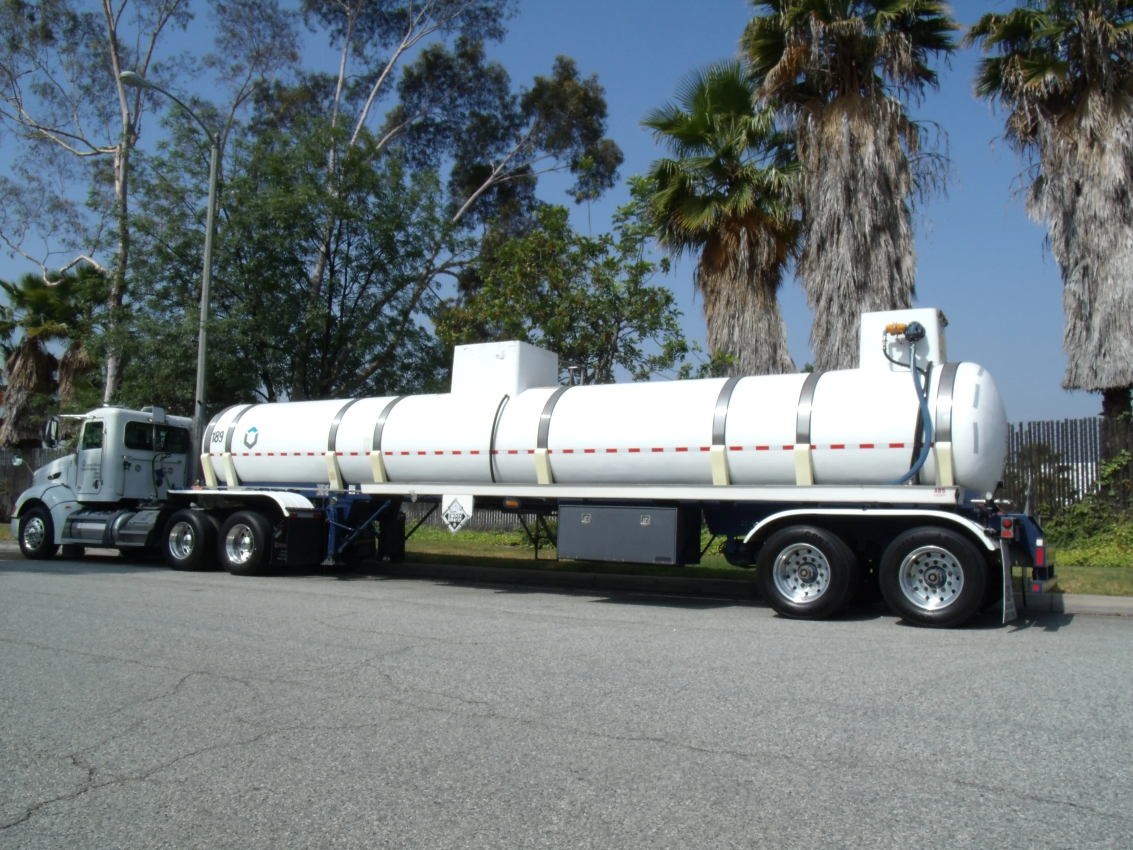 the large tanker truck has white tanks on its back