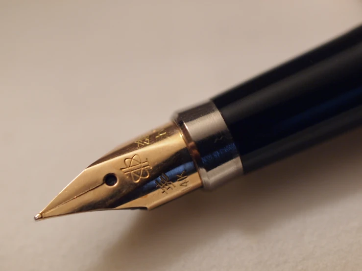 a pen with gold writing that looks like it has a fancy handle