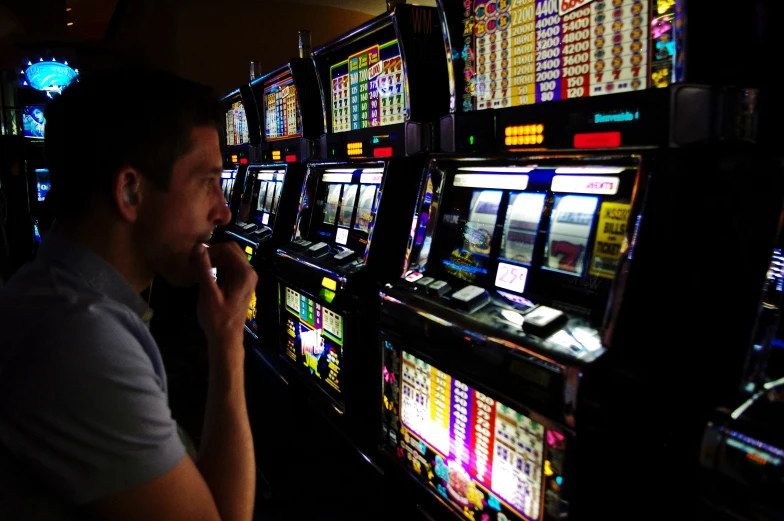 there is a man with a cigarette next to a slot machine