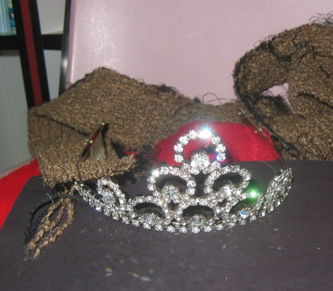 a tiara, gloves, and hat all sit on the table