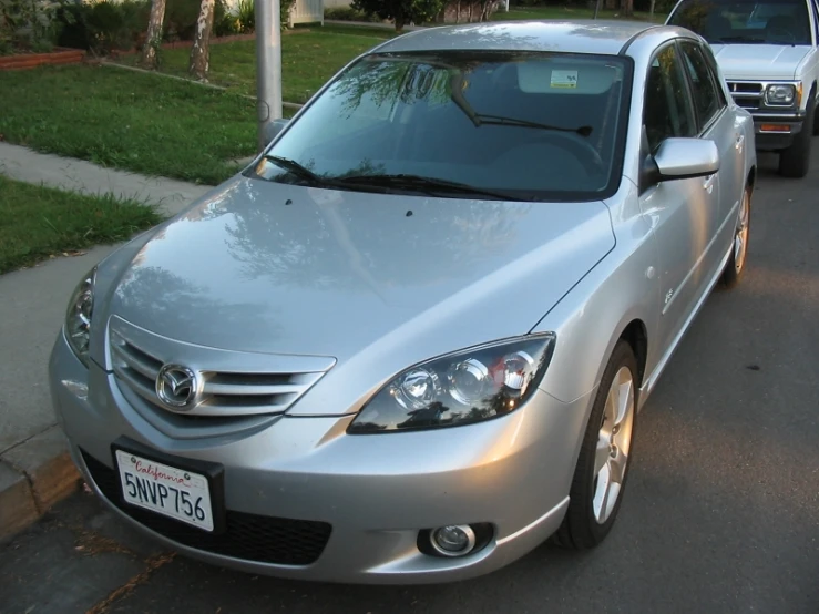 a silver car is parked next to a curb