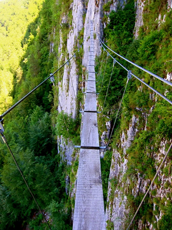 an abandoned rope - link suspension going to nowhere in the mountains