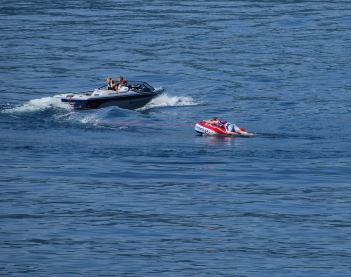 two boats with motor boat attached in the water