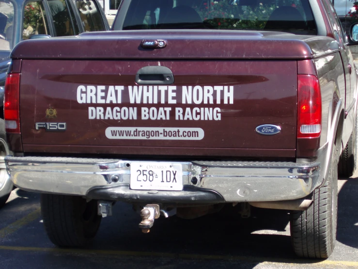 the back end of a truck is painted with white north dragon boat racing stickers