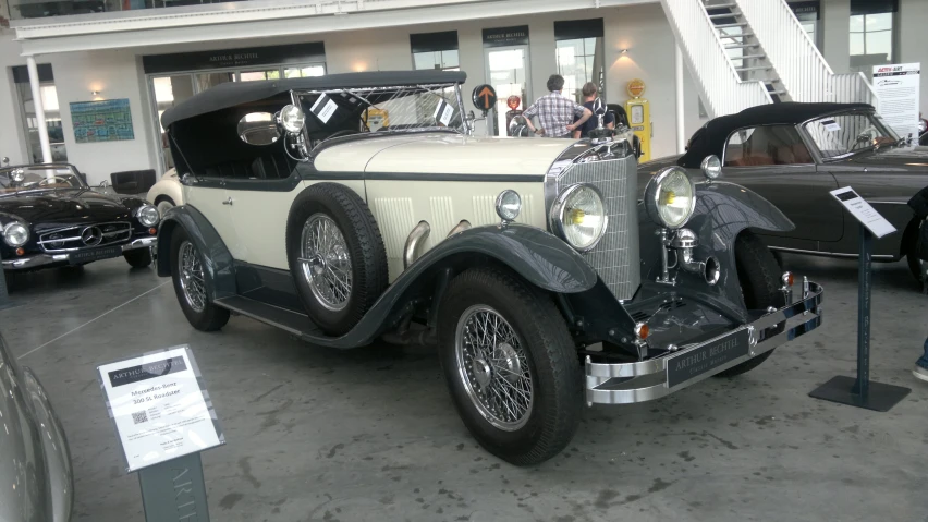 an old model white car parked inside of a building