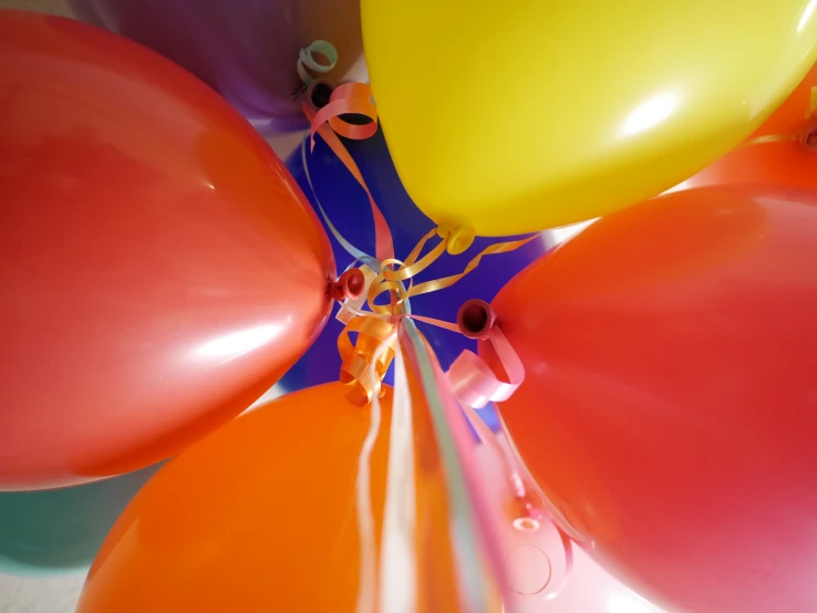 there are many balloons of different colors hanging from a string