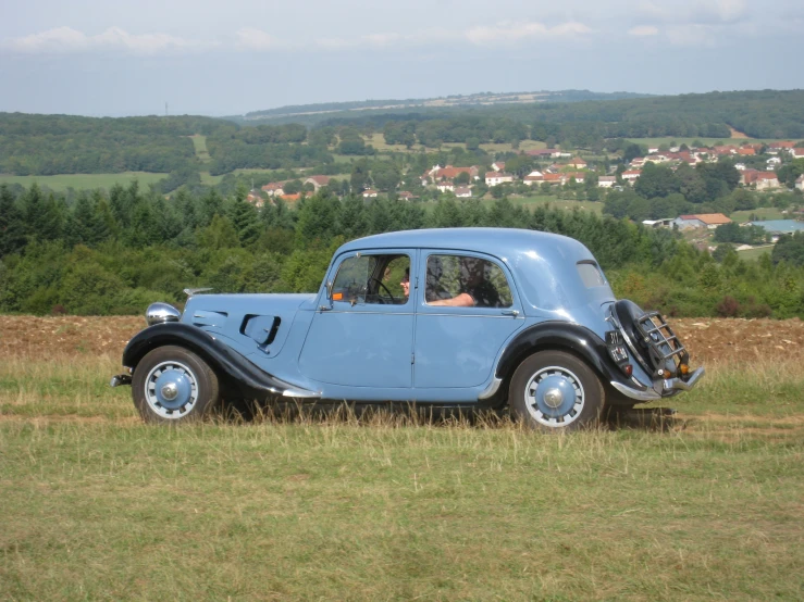 the blue car is parked on the grass