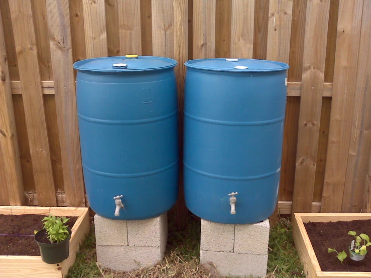 two blue barrel tanks in the back yard