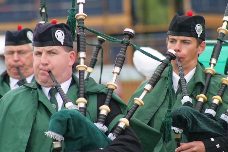 men in green costumes performing pipe band music