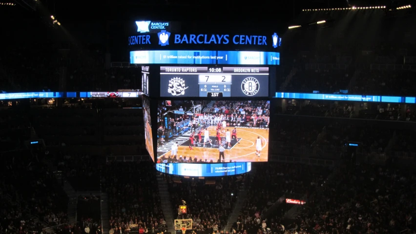 a basketball game is being played on an enormous television screen