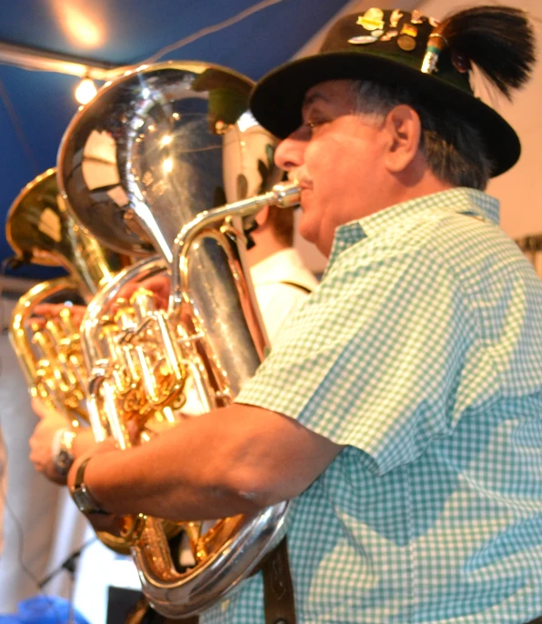 a man in a blue shirt playing a trumpet