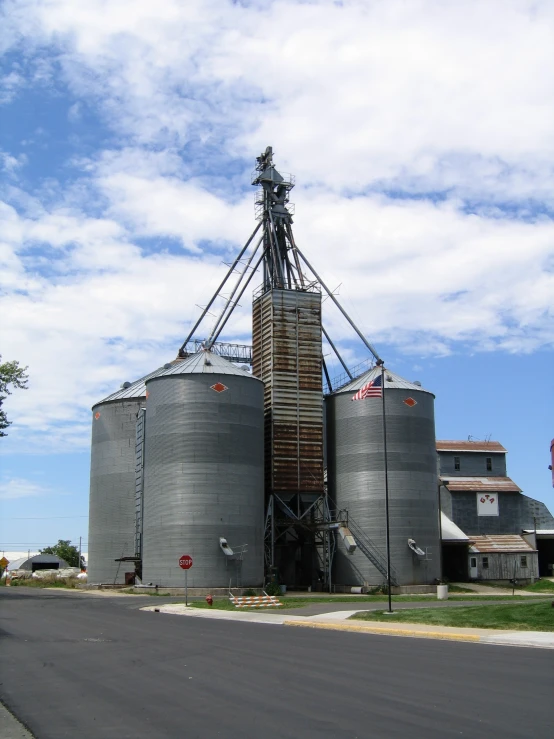 a large grain storage plant next to a small road