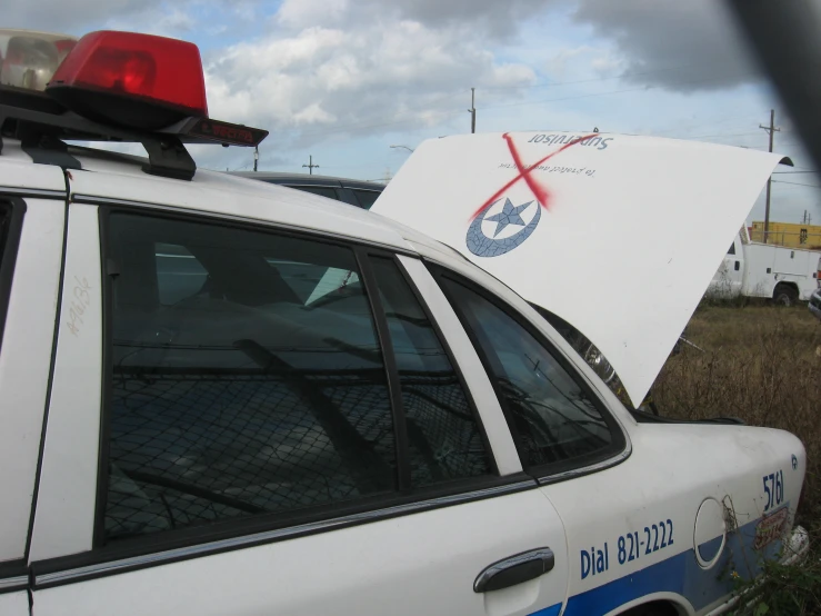 the back window of a police car with its rear end broken