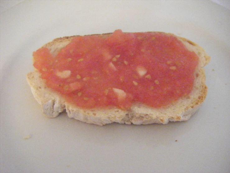 tomato sauce on top of bread with a white plate