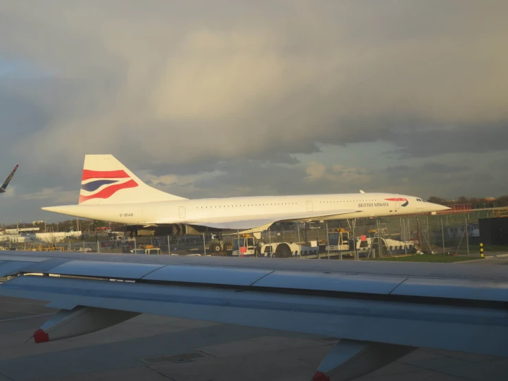 an airplane that is on a runway with a few other planes in the background