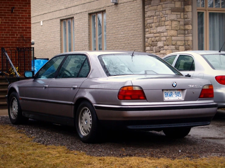 a grey car parked in front of a brick building