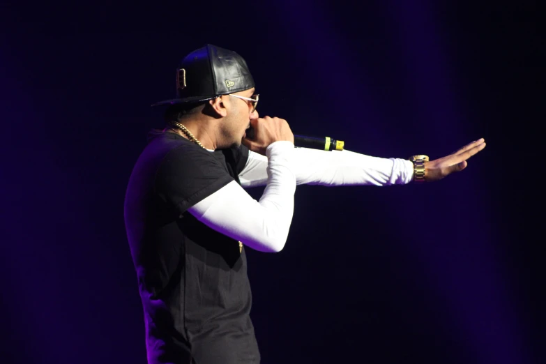 a male in a black and white hat is holding a microphone