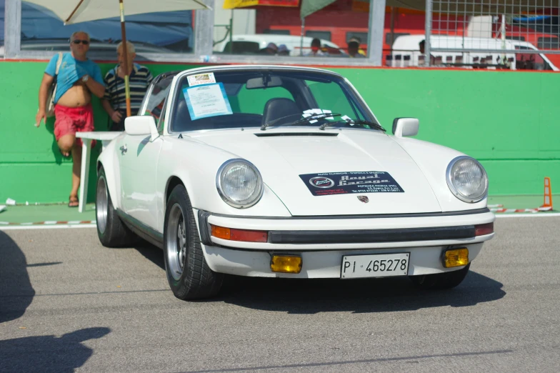 a white classic car parked by the side of the road