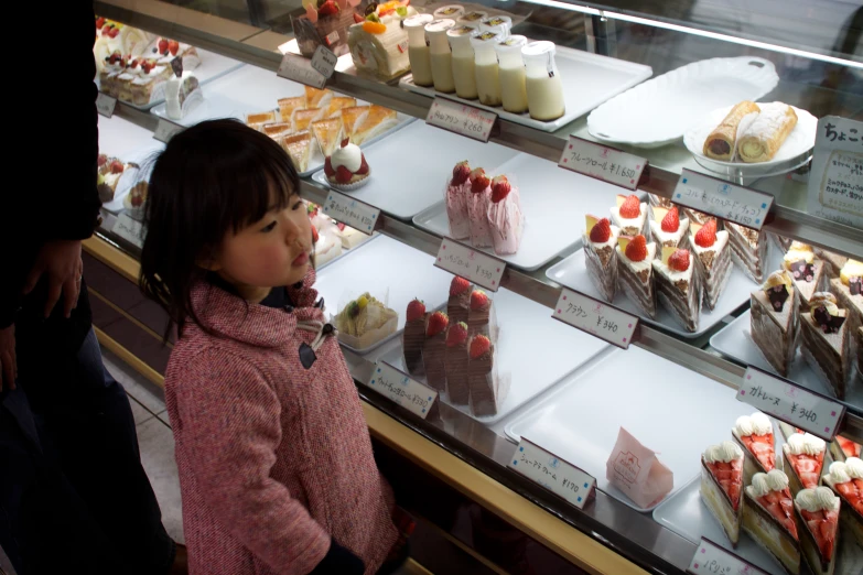 a little girl standing in front of a display case