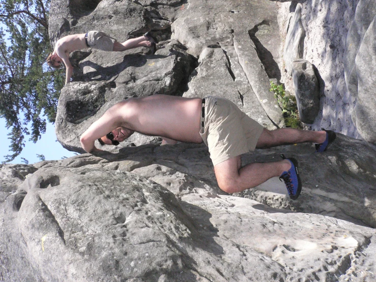 a man climbs up on top of a boulder