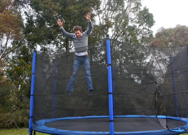 a person is jumping on a trampoline in a field