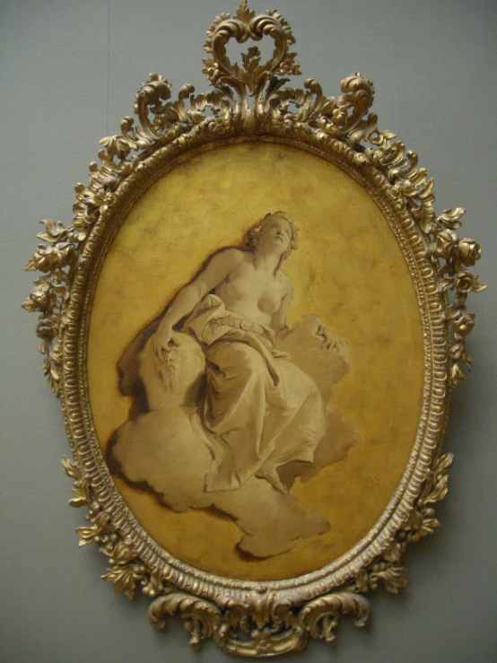 an oval gold framed painting with a young woman seated