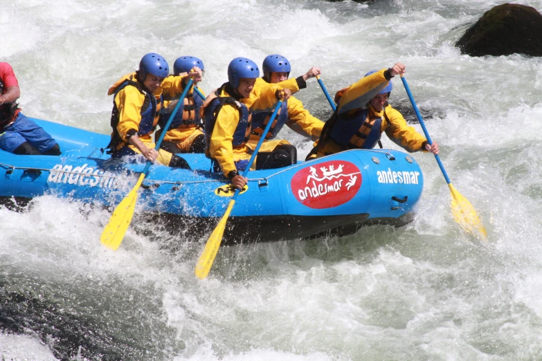 people in blue raft with white water