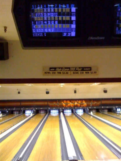 an orange is laying on bowling balls in the lanes