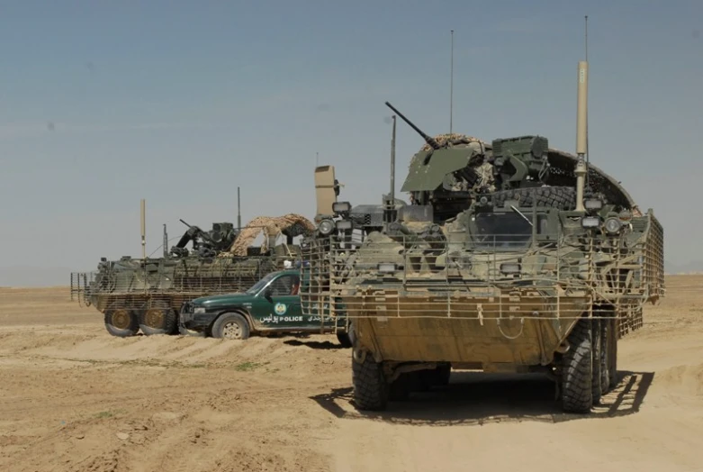 tanks parked on the dirt near the road