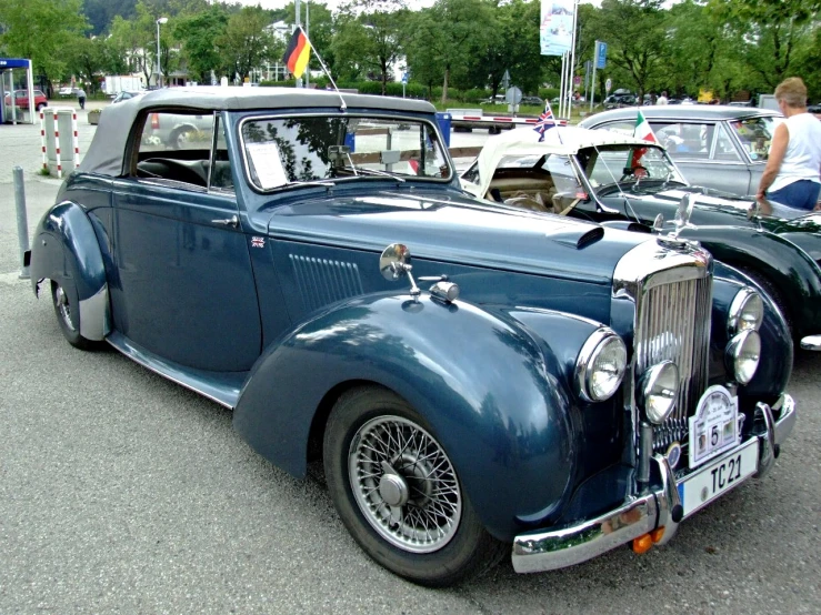 an antique car in a parking lot with other cars